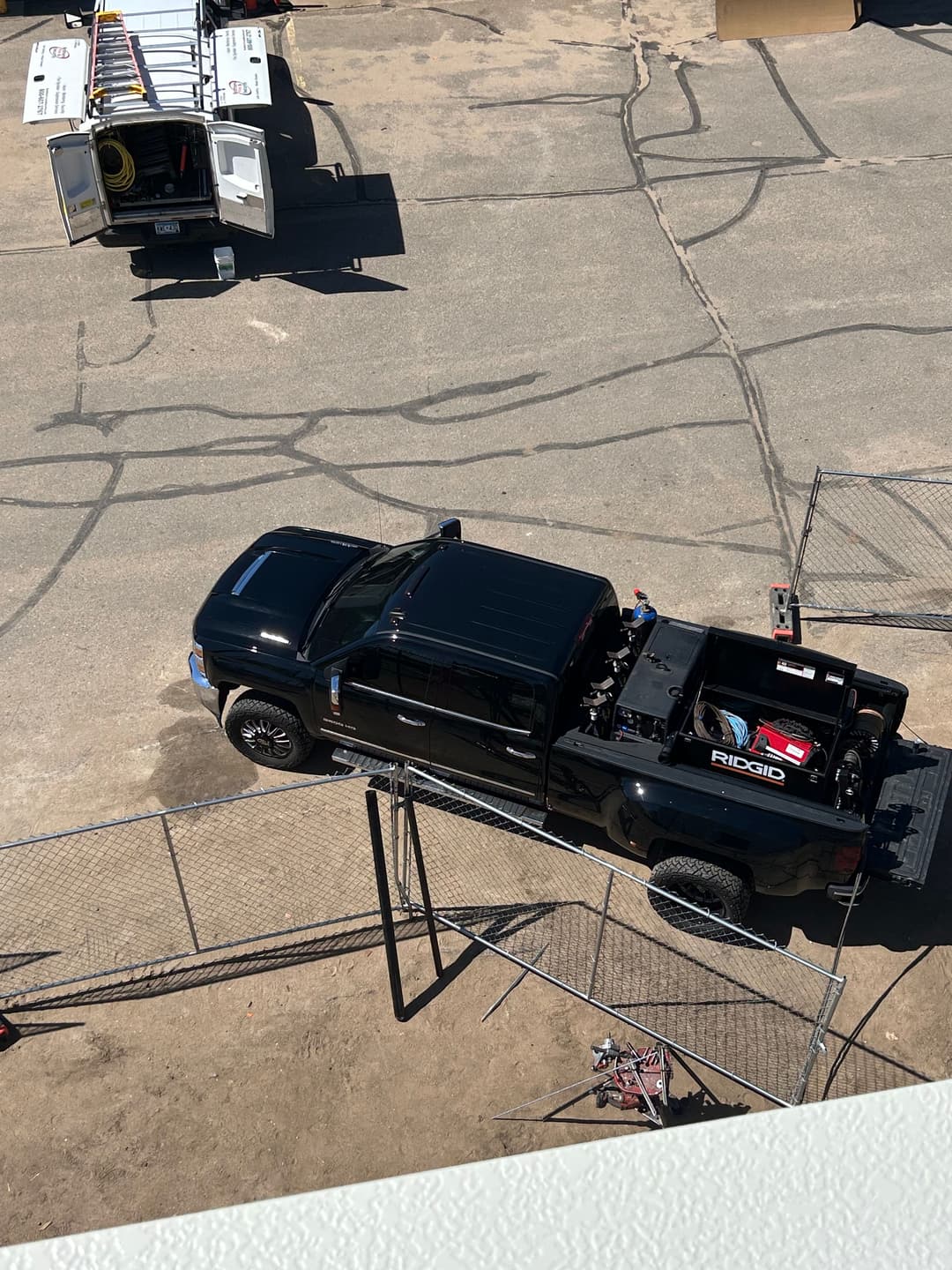 Black pickup truck with tools parked on a construction site.