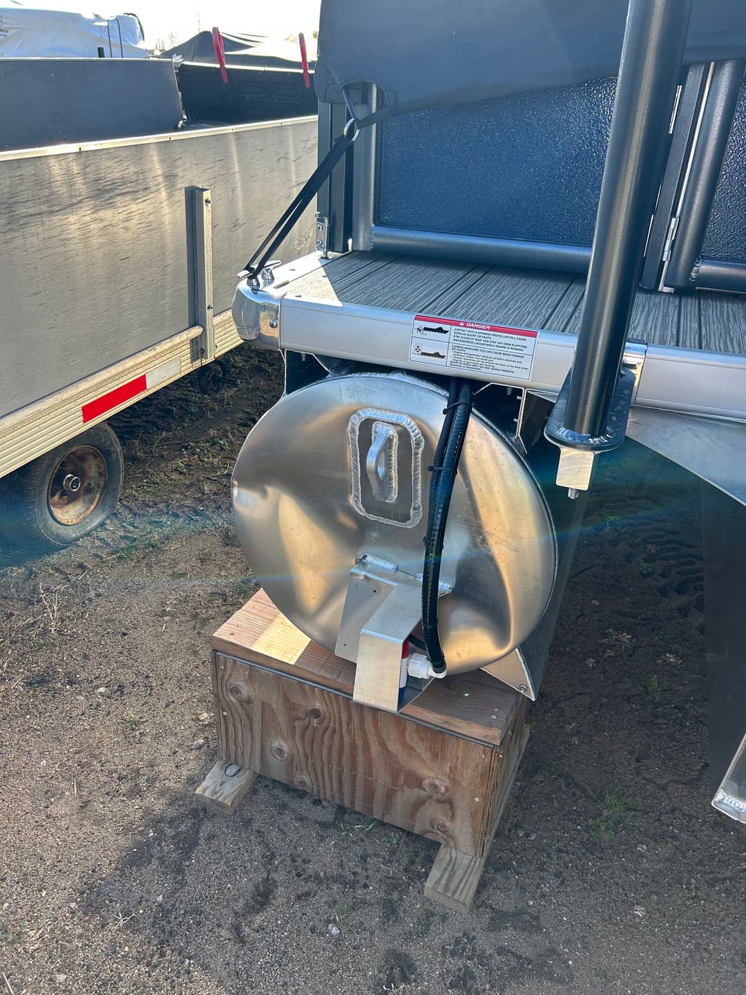 Stainless steel marine boat propeller hub mounted on wooden support.