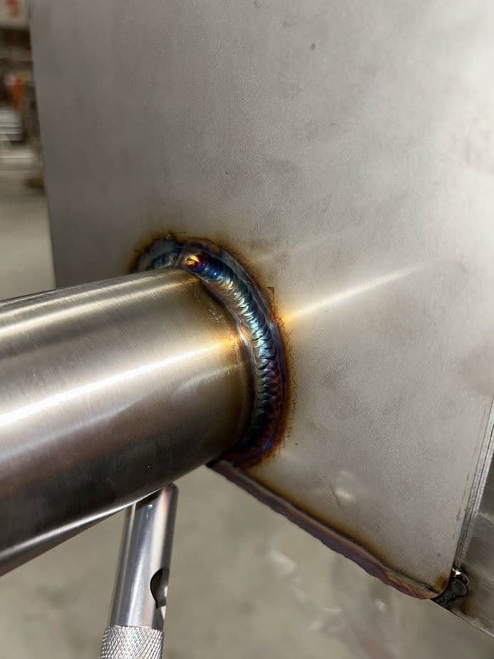 Close-up of stainless steel weld joint showcasing vibrant color and smooth finish.