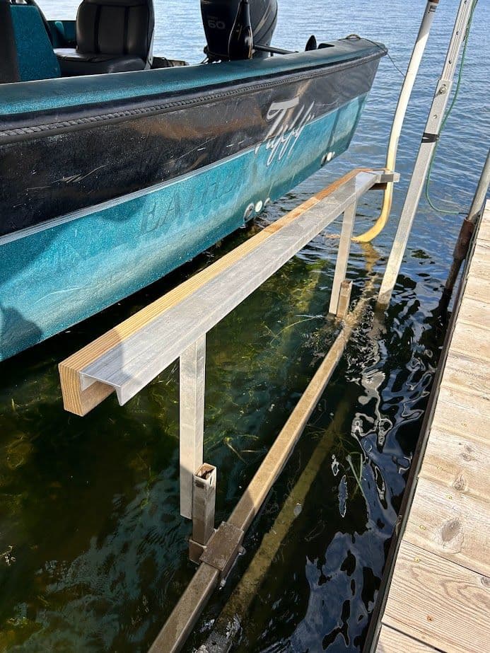Boat dock with metal and wooden structure for securing a boat at the water's edge.