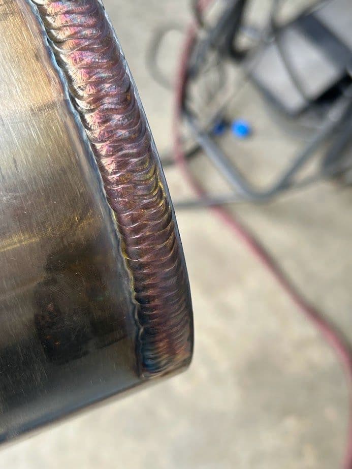 Close-up of a polished welding bead on metal, showcasing detailed craftsmanship and design.