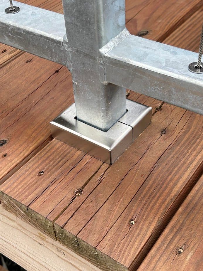 Metal post base mounted on wooden deck, showcasing sturdy construction and clean design.