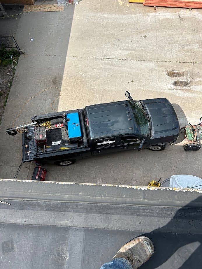 Aerial view of a work truck with equipment parked on a concrete surface.
