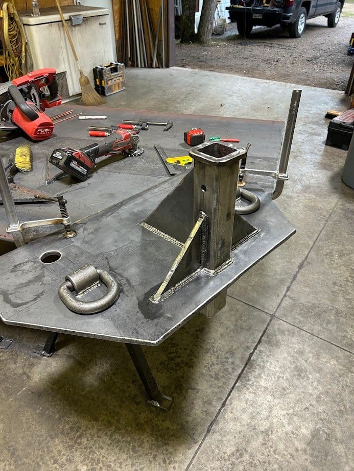 Metal fabrication project showcasing a newly welded assembly on a workshop table with tools.