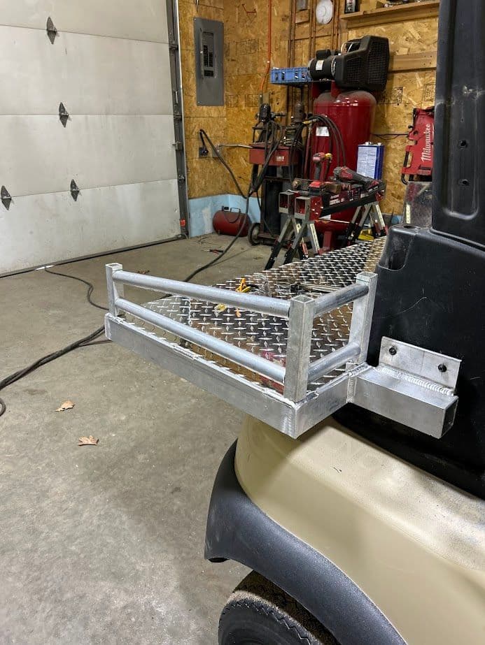 Aluminum tool rack mounted on a golf cart in a workshop with tools in the background.