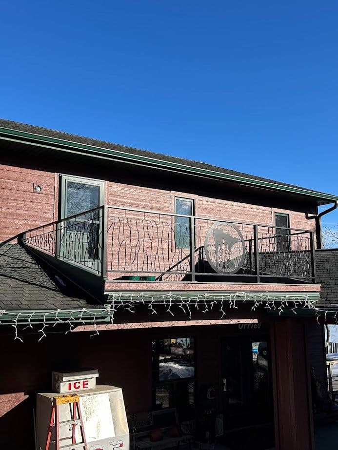 Two-story building with a balcony, winter decorations, and a clear blue sky.