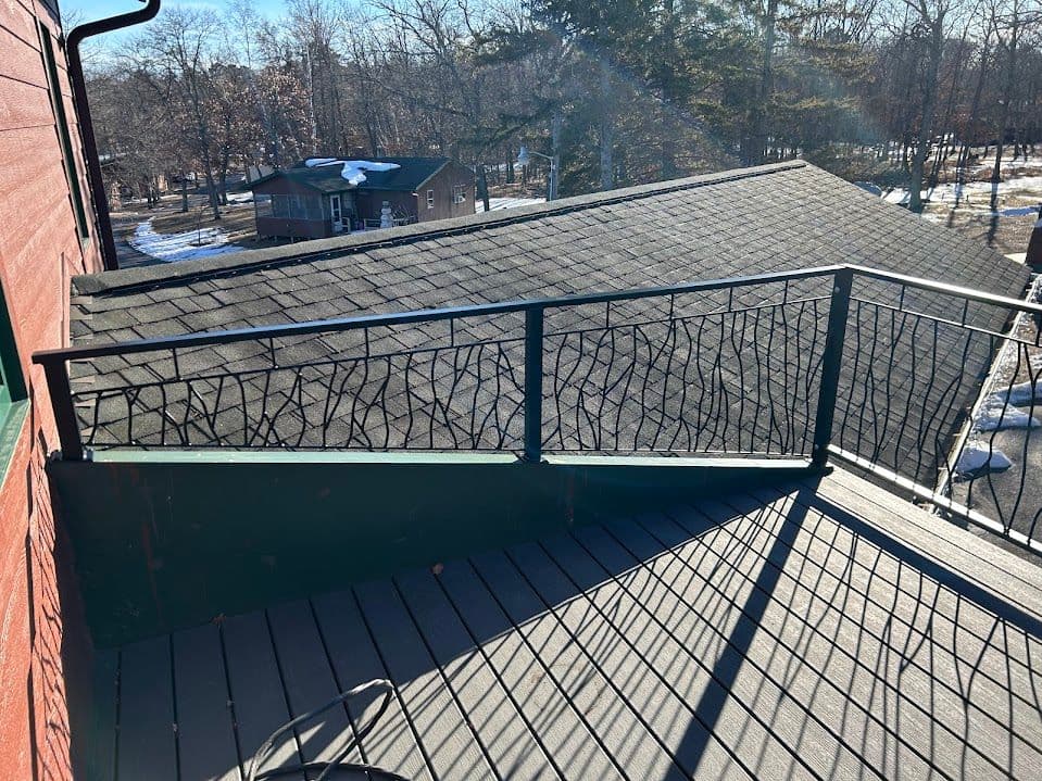 Roof view from a balcony showing a decorative railing and surrounding winter landscape.