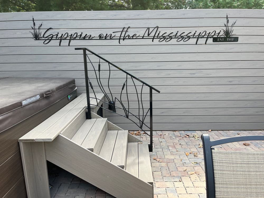Outdoor stairs leading to a hot tub with "Gather on the Mississippi" sign above.